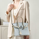 Minimalistische Damen Tasche aus hellblauem, weißem, gekörntem Leder mit oberem Griff